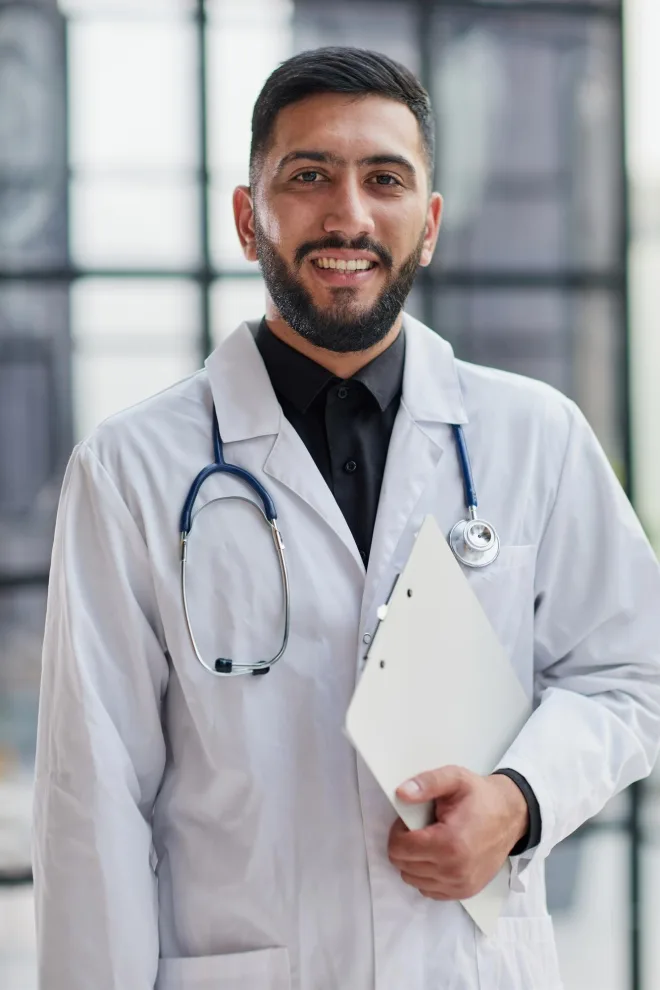 Dr. Ashton Mraz, DDS, practice owner at SereneSmile Anesthesia Group, wearing a white coat and stethoscope